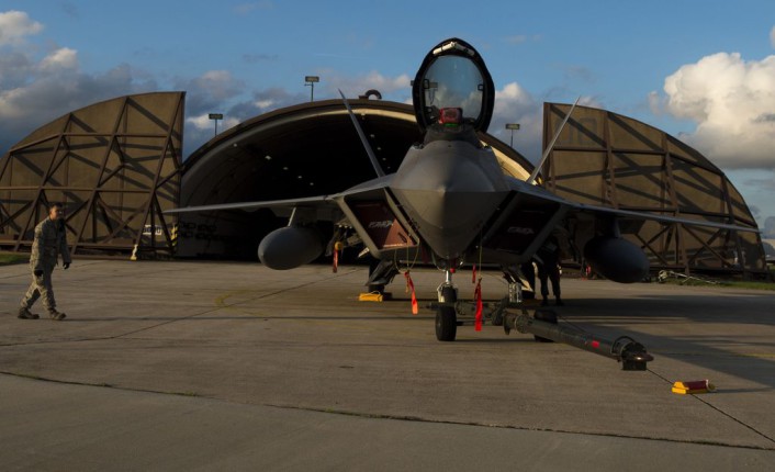 A member of the 95th Fighter Squadron at Tyndall Air Force Base, Fla., observes an F-22 Raptor fighter aircraft at Spangdahlem Air Base, Germany, Aug. 28, 2015. The U.S. Air Force deployed four F-22 Raptors, one C-17 Globemaster III and more than 50 Airmen to Spangdahlem in support of the first F-22 European training deployment. The inaugural F-22 training deployment to Europe is funded by the European Reassurance Initiative, a $1 billion pledge announced by President Obama in March 2014. (U.S. Air Force photo by Airman 1st Class Luke Kitterman/Released)