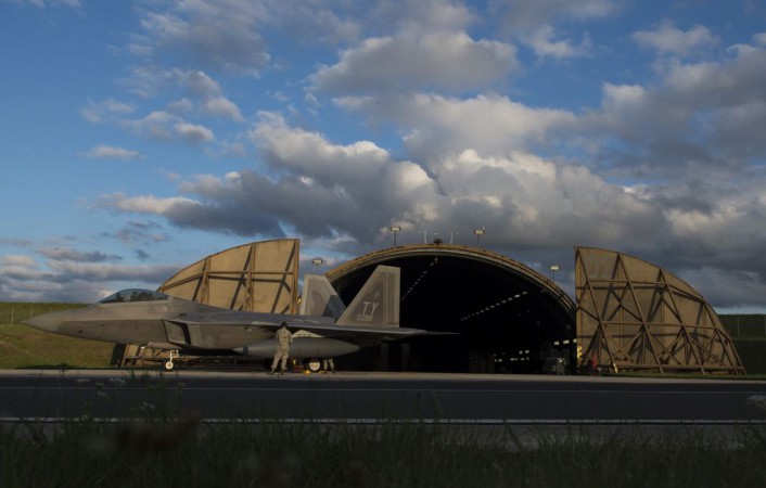A member of the 95th Fighter Squadron at Tyndall Air Force Base, Fla., observes an F-22 Raptor fighter aircraft at Spangdahlem Air Base, Germany, Aug. 28, 2015. The U.S. Air Force deployed four F-22 Raptors, one C-17 Globemaster III and more than 50 Airmen to Spangdahlem in support of the first F-22 European training deployment. The inaugural F-22 training deployment to Europe is funded by the European Reassurance Initiative, a $1 billion pledge announced by President Obama in March 2014. (U.S. Air Force photo by Airman 1st Class Luke Kitterman/Released)