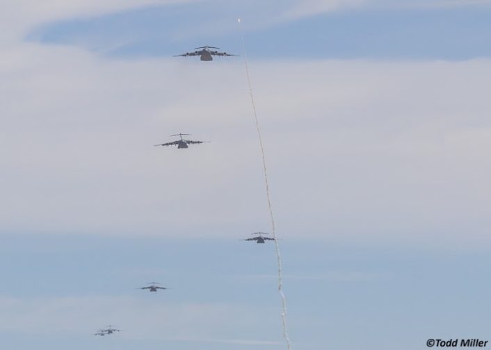 Ground launched rocket streaks in front of C-17A's incoming for airdrop on Keno field in the NTTR during JFEX (June 2016).